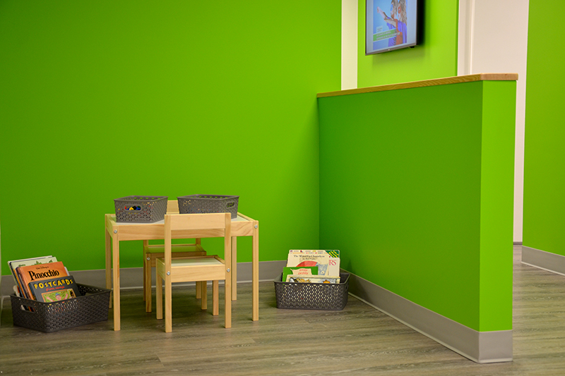 Children's play table in a bright green corner.