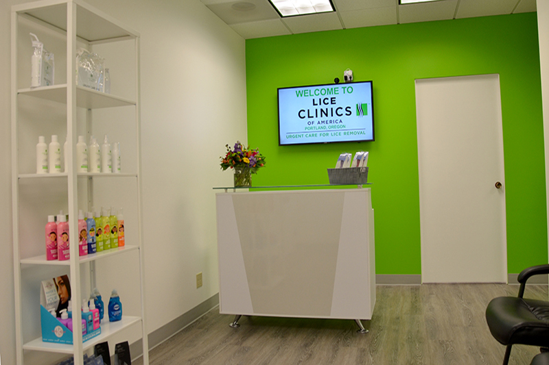 Reception desk with a welcome screen and product shelves.