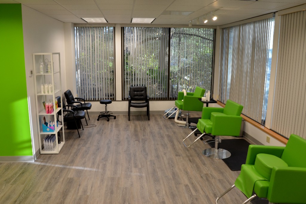 Treatment room with several green chairs along the windows.